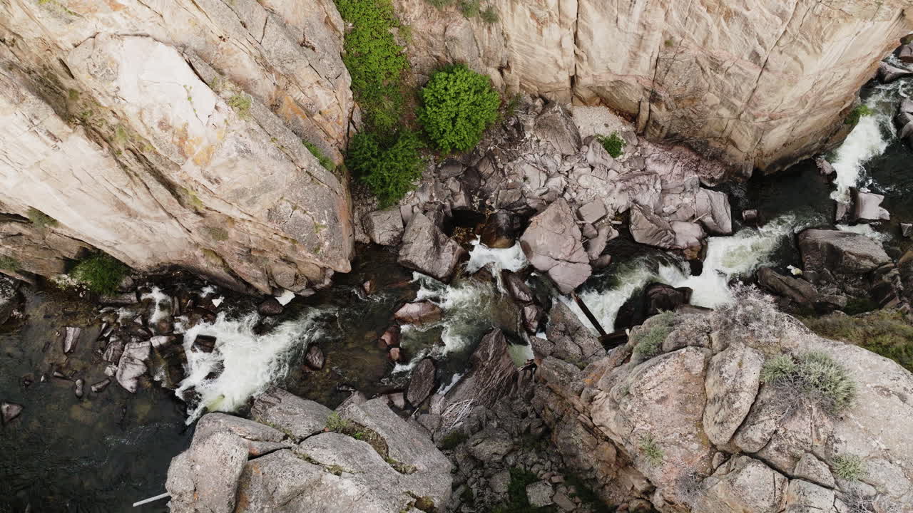 Drone perspective capturing geological structures and a flowing river in a canyon.