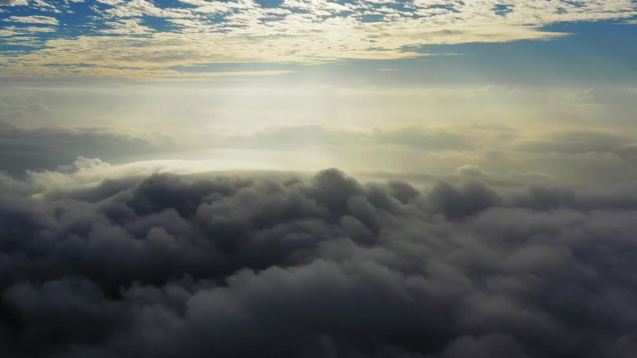vista panorámica de la luz del sol sobre nubes masivas y niebla, toma aérea