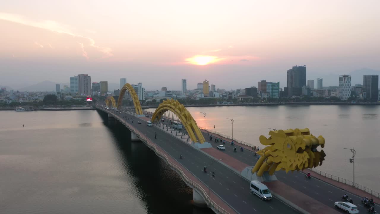 colorida imagen aérea del puente del dragón cau rong, el tráfico y el horizonte de la ciudad durante la puesta de sol en danang, vietnam