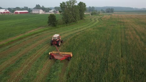 using a hyrdoswing swather, a wisconsin farmer cuts a field of alfalfa and grass