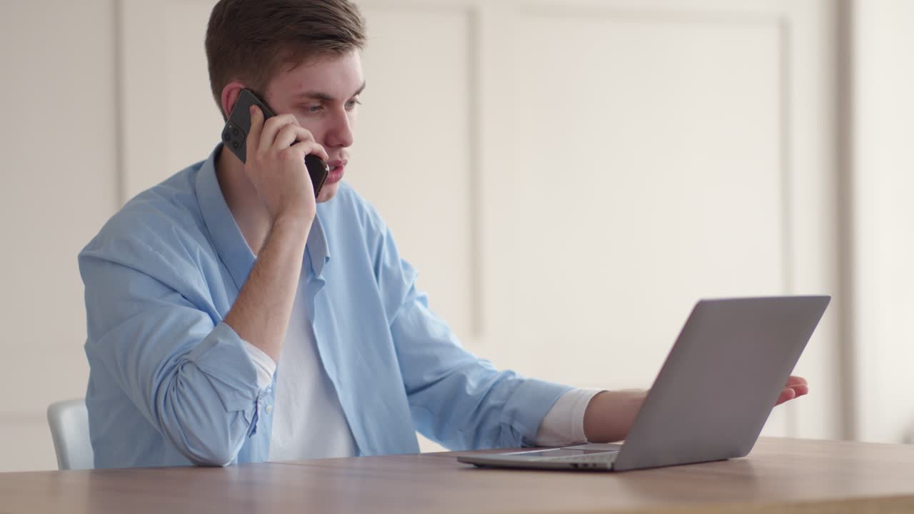 Man on phone call working on laptop
