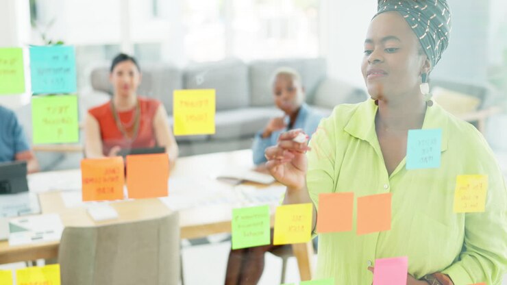 Glass wall, post it and black woman leader