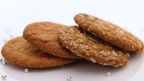 oatmeal cookie rotation on the table with sesame seeds on white background. wheat fall on dietary cookies. eat oatmeal cookies. the concept of making chip cookies