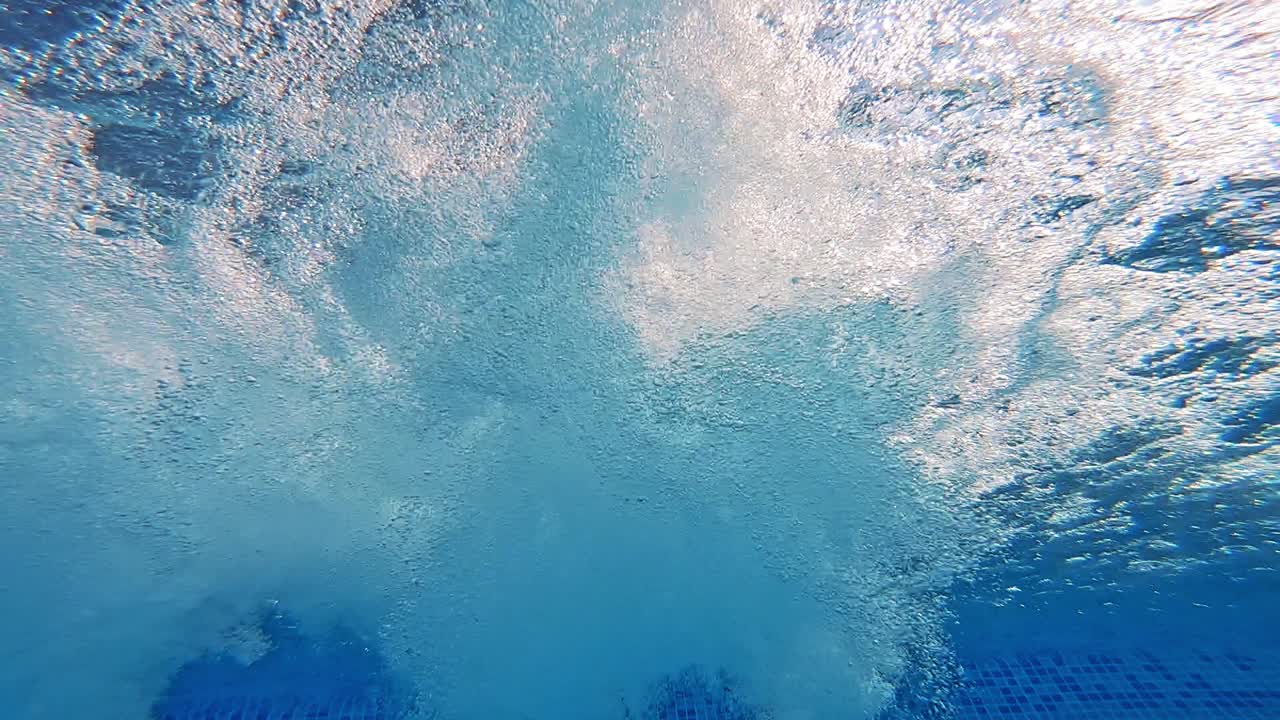 Bubbles inside the swimming pool. Beautiful underwater view of a pool with lots of white bubbles in blue water.