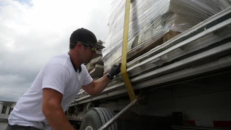 truck driver secures load on his truckbed