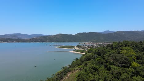 Flying-over-the-Atlantic-Forest-and-the-sea-in-Paraty,-Rio-de-Janeiro,-Brazil