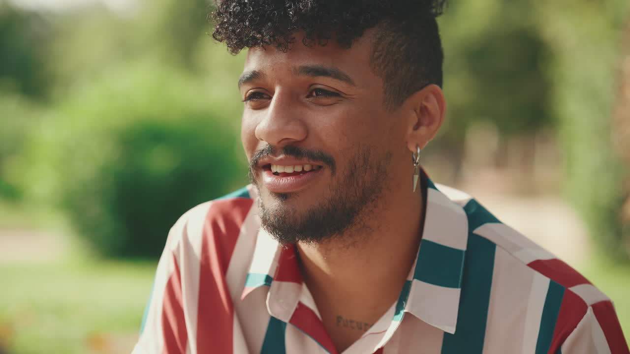 retrato de un hombre sonriente con el cabello rizado