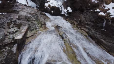 Riskanter-Drohnenschuss-Unter-Einer-Brücke-Und-über-Einem-Wasserfall-Im-Winter