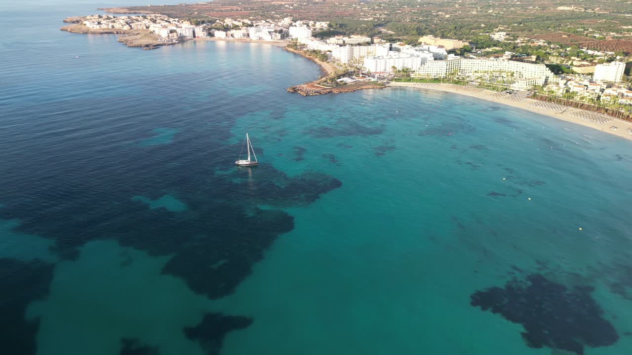 velero flotando en el agua azul tranquila y clara del océano cerca de sa coma en mallorca, españa