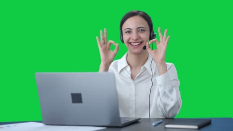 chica feliz del centro de llamadas india mostrando bien señal pantalla verde