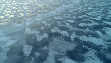 drone gliding over ice sea with the sun going down