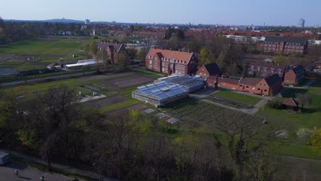 Smooth-aerial-top-view-flight-Berlin-Greenhouse-red-brick-house-Dahlem-Centre-of-Plant-Sciences