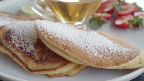 delicious pancakes with strawberries and syrup