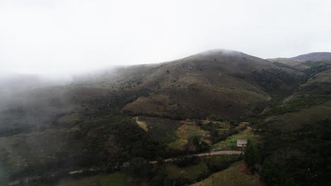 Forward-aerial-shot-of-hills-under-clouds-during-daytime