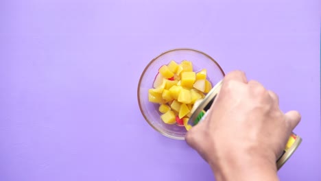 vertiendo ensalada de frutas enlatadas en un cuenco