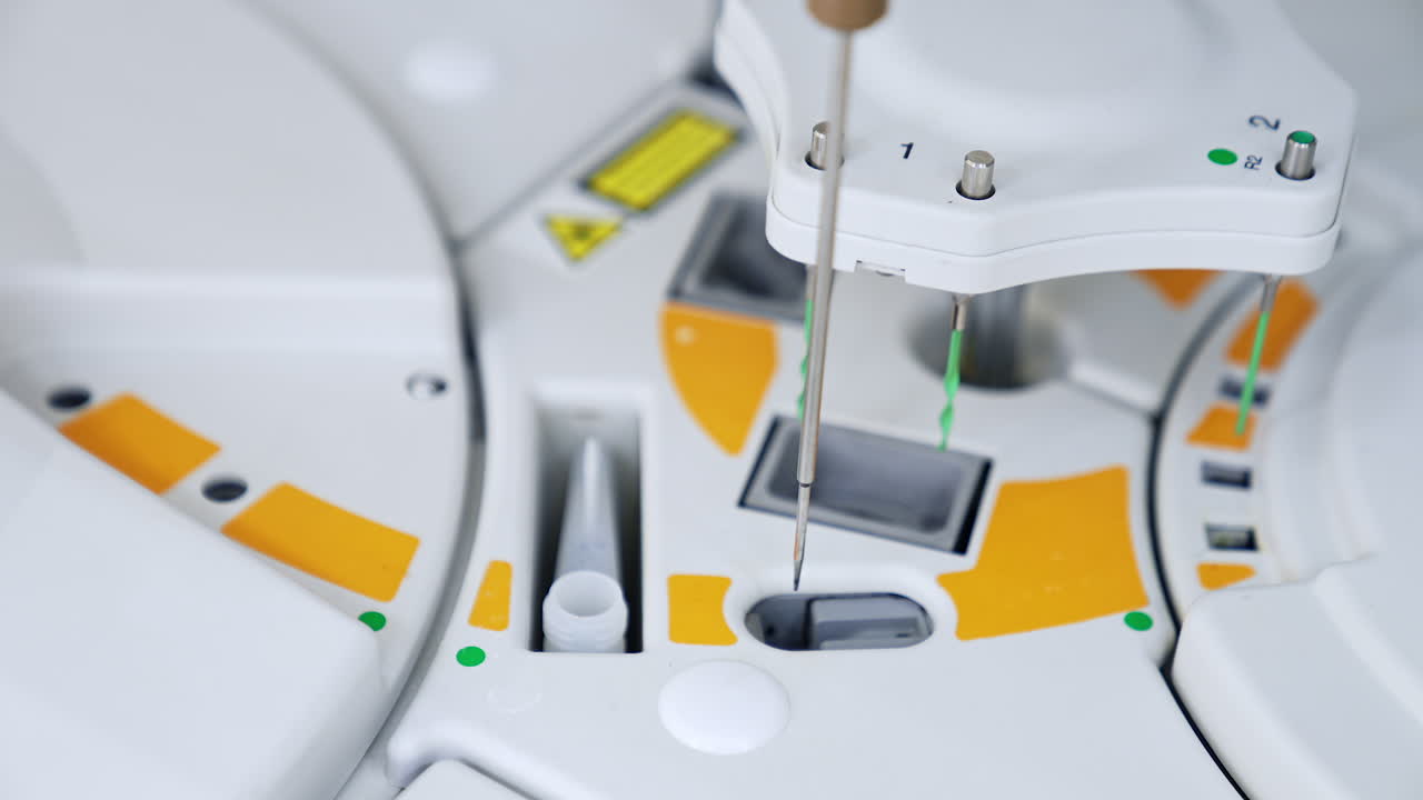 Slots at the medical testing equipment with metal needle moving from one slot to another. New equipment at modern science laboratory.