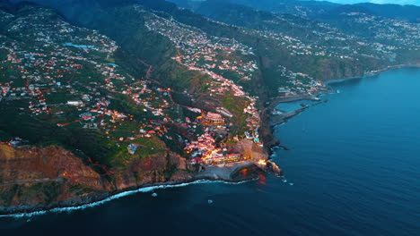 highly populated area at the slope of the mountain descending to the waterscape of the atlantic ocean. aerial perspective on the coast of the madeira islands, portugal.