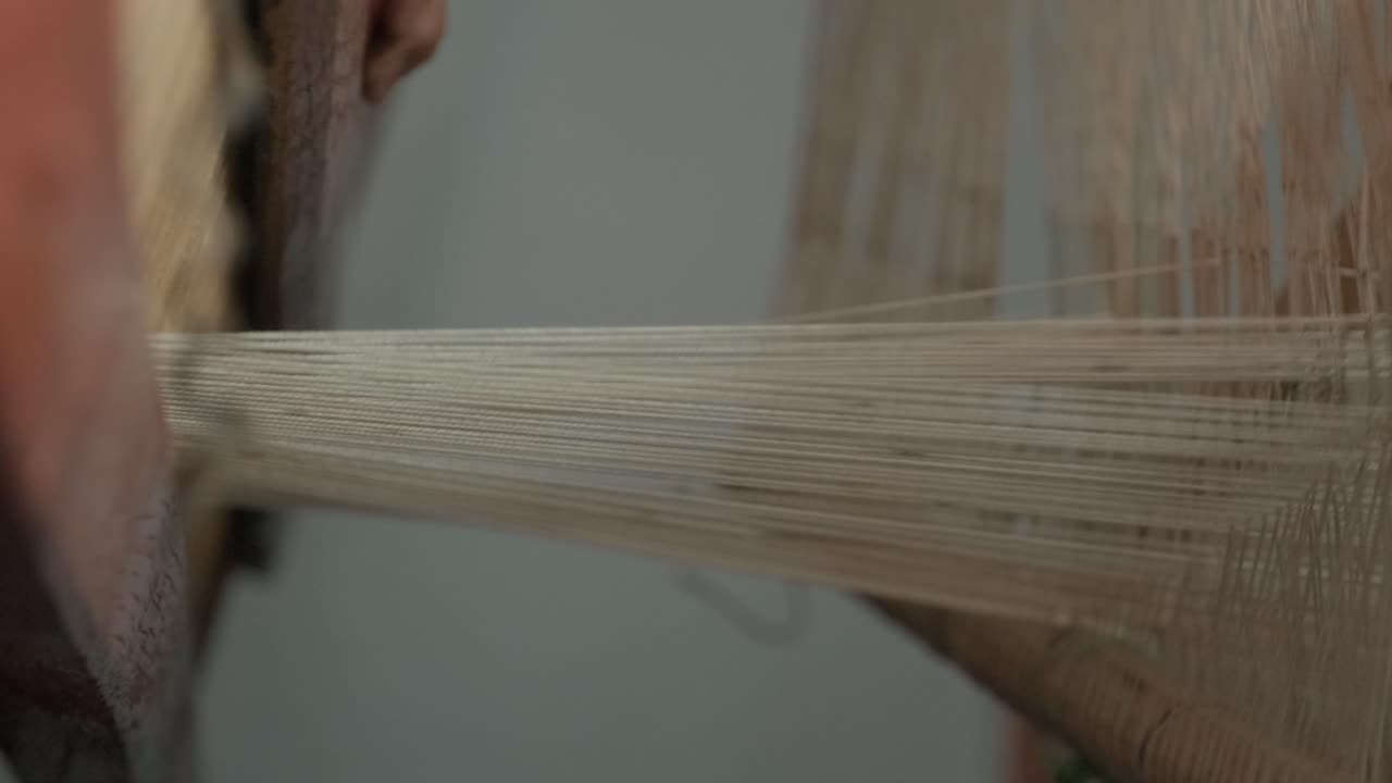 el tejedor hace tela en el telar étnico