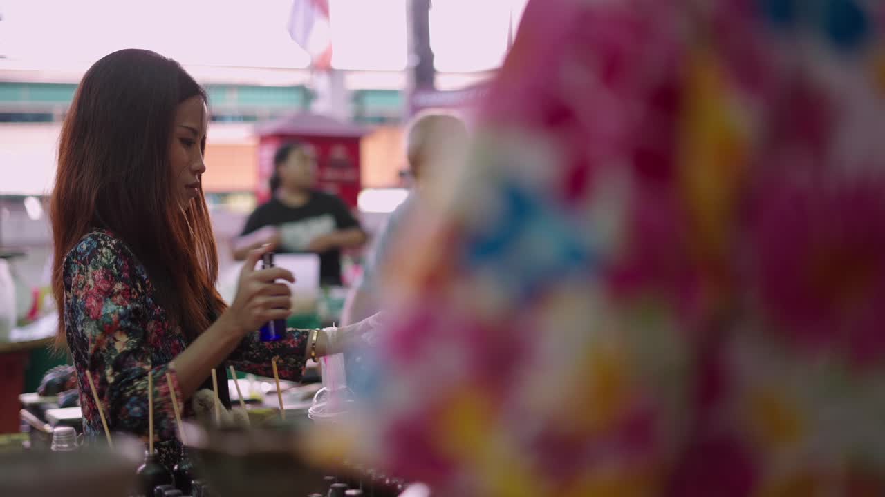 Woman browsing or working at a bustling market stall