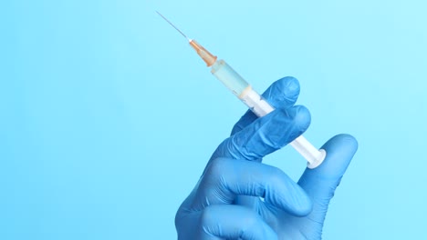 syringe held by gloved hand