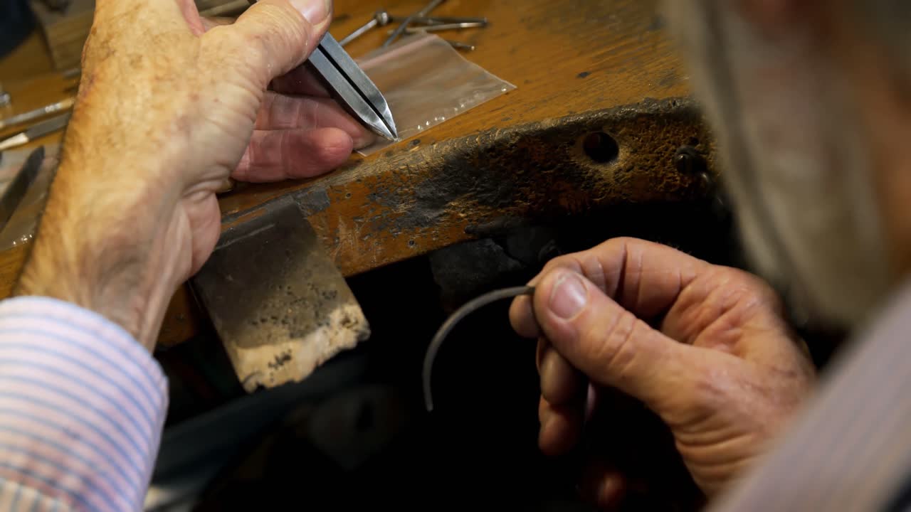 orfebre fijando el diamante en un brazalete de 4k