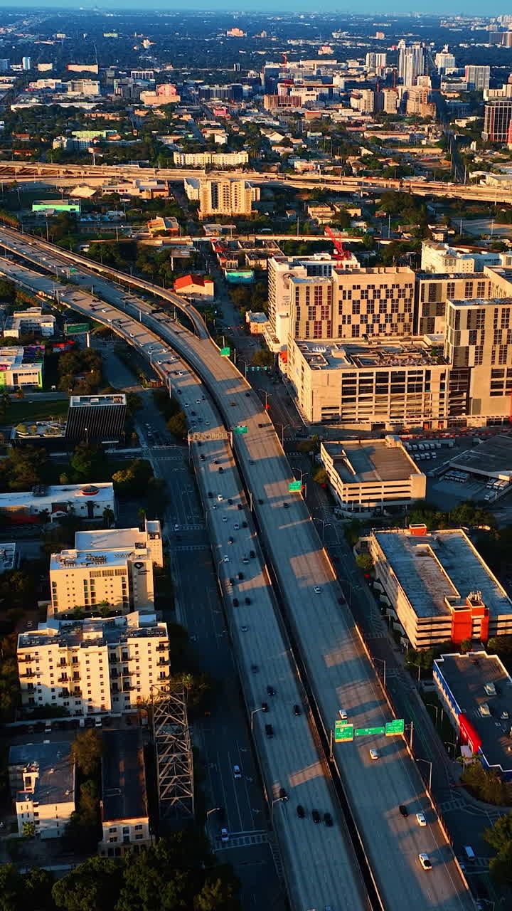 Beautiful scenery of sunny Miami at sundown. Drone going down above the highways with transport moving by. Vertical video