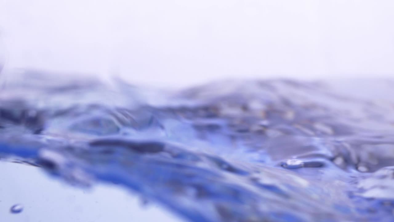 슬로우 모션으로 프레임을 채우는 물 스플래시 표면 물 방울과 흰색 배경에 기포가 있는 액체 흔들기