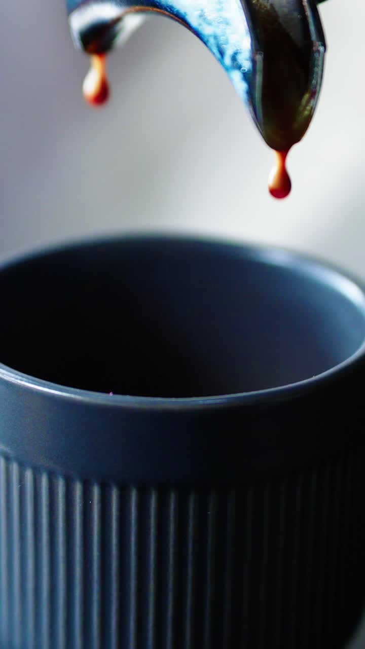 Espresso fresco che viene erogato e gocciola in una tazza da caffè