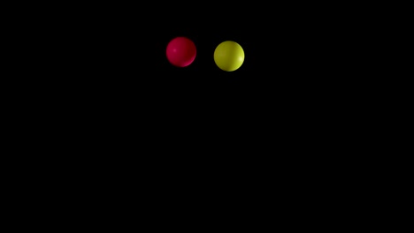 red and yellow balls bouncing in darkness