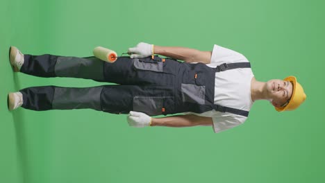 full body of asian man painter wearing safety helmet standing and look around in the green screen background studio