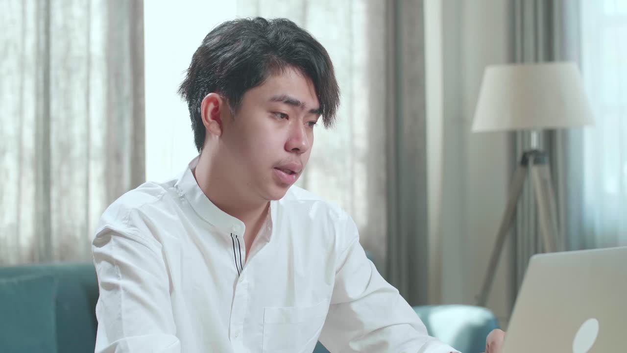 Close Up Of Asian Man Student Being Tired While Typing On Computer At Home