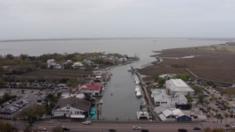 aerial wide reverse pullback shot of shem creek on a hazy day in mount pleasant, south carolina