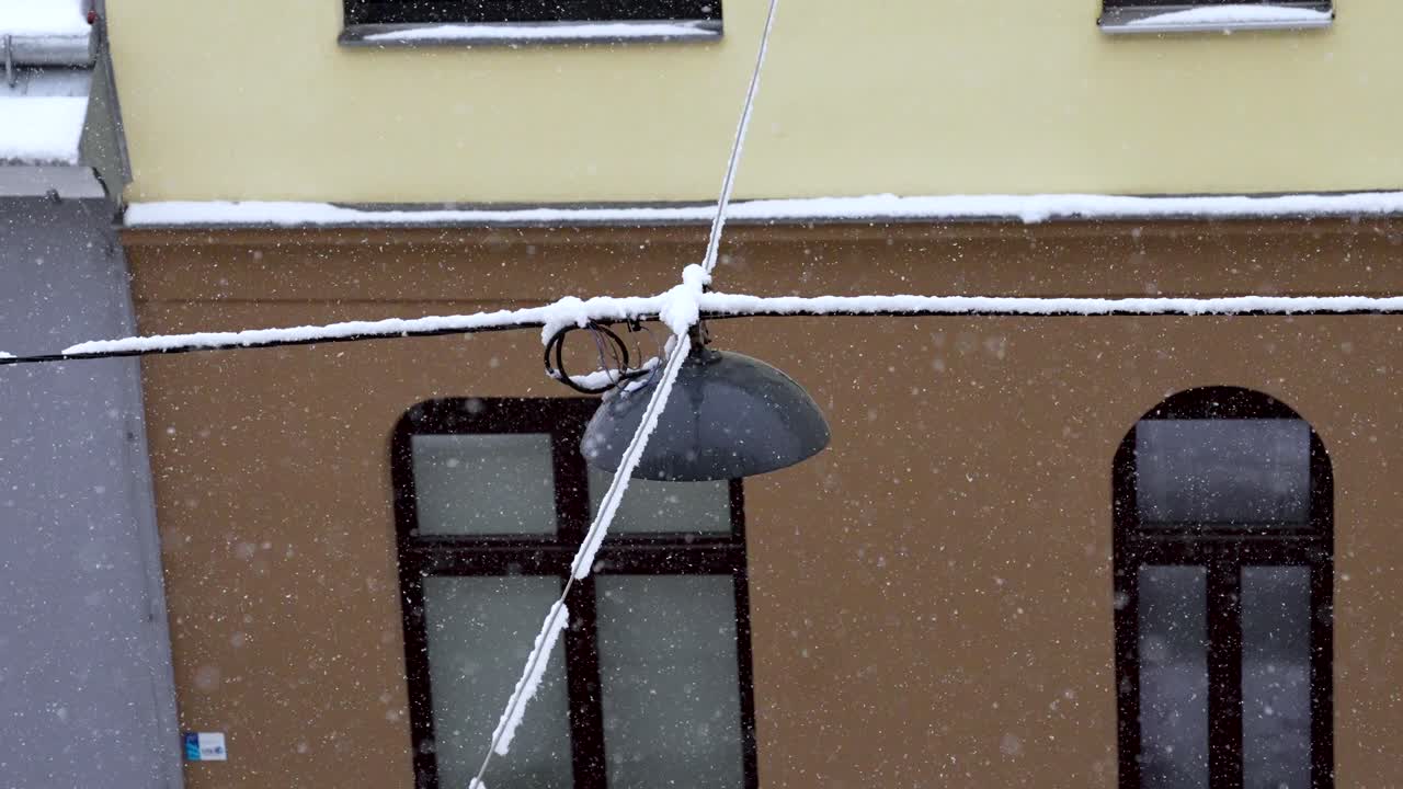 View from window on hanging street lights while it is calming snowing in vienna