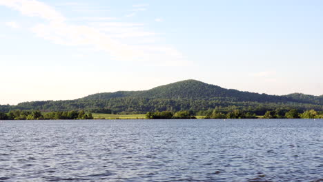 the waters of a lake at the foot of a small hill