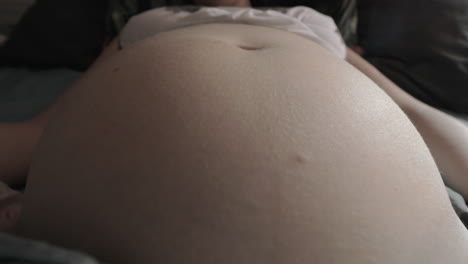 el vientre de una mujer embarazada y el bebé se mueve dentro