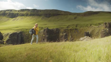 young hiker gets ready for the path over green mountain landscape