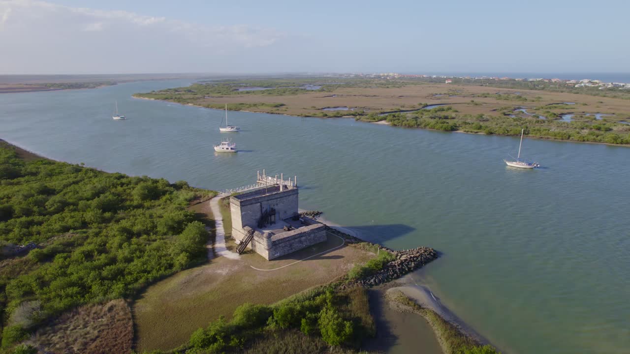 Stemningsfuldt luftfoto af St. Augustine-fæstningen kontrasteret mod den moderne bysilhuet.