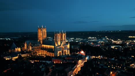 Aerial-drone-video-captures-the-renowned-Lincoln-Cathedral-in-Lincolnshire,-UK,-at-dusk,-showcasing-its-majestic-Gothic-architecture-with-illumination