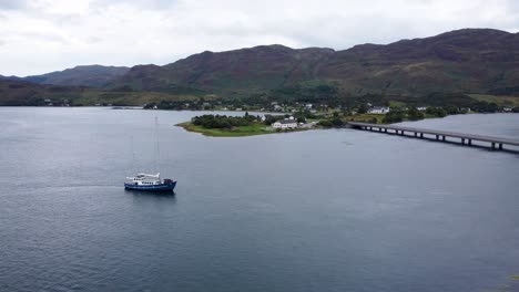 Boat-on-Loch-Long-near-Dornie-Community-Hall,-near-Eilean-Donan-Castle,-West-Coast-of-Scotland,-Scottish-Highlands---Aerial-Drone-4k-HD-Footage-Fly-Towards