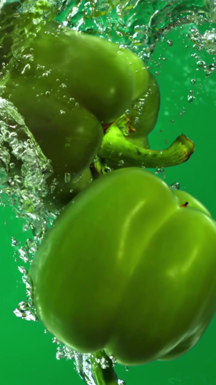 Pimentões Verdes Caindo na Água com Bolhas