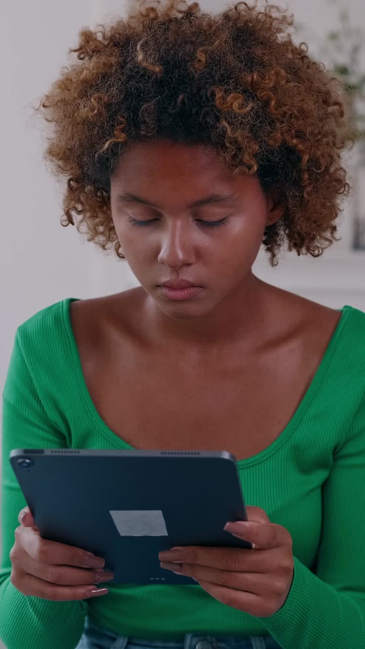Young woman focused on a tablet reading and interacting with digital content