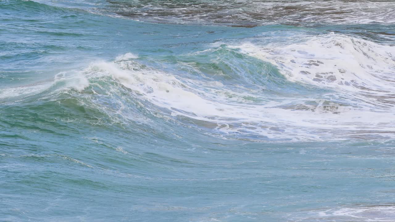 Dynamic ocean waves crash against the shore at Port Campbell, captured in natural lighting with a focus on movement and energy