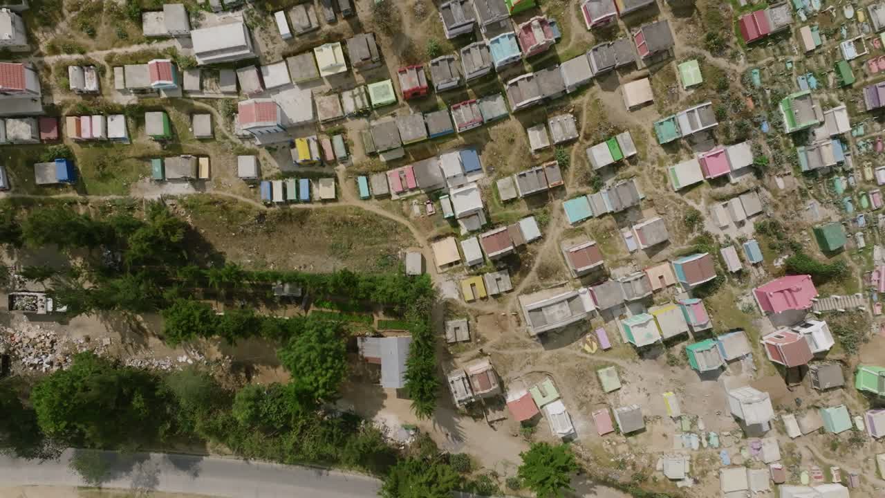 imágenes aéreas de arriba hacia abajo aceleradas que cruzan una carretera con una motocicleta y se mueven sobre un colorido cementerio en la ciudad de chichicastenango, guatemala