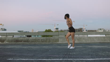 young woman dances alone on empty street