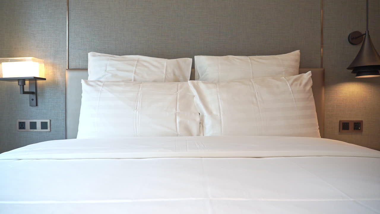 pan a través de una cama de hotel con almohadas apiladas