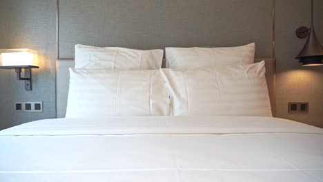 pan across a hotel bed with stacked pillows