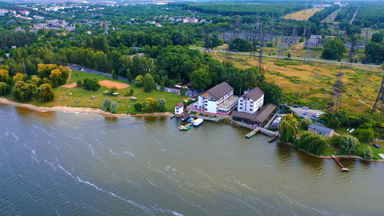 Beautiful landscape of the city on the river bank. Urban area with exuberant greenery from aerial perspective.