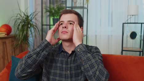 displeased young teen man rubbing temples to cure headache problem, suffering from migraine, stress