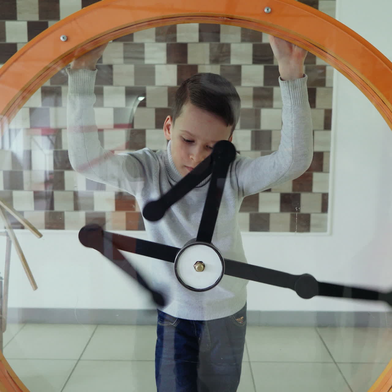 Child views the perpetual motion machine in the children's science museum. Boy in science center. Square video