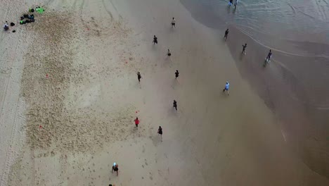 Vista-Aérea-De-Arriba-Hacia-Abajo-De-Personas-Corriendo-En-La-Playa